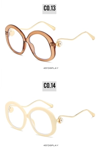 Detail of round pearl sunglasses showing amber and white frames with metal temples
