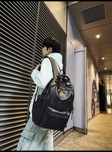 Dettaglio street style dello zaino in pelle PU nera indossato su una spalla