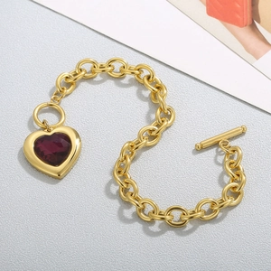 Detail of gold chain bracelet featuring red heart crystal and functional OT toggle clasp
