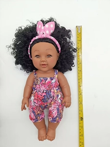 Detailed overhead view showing 36cm black baby doll with pink headband and floral jumpsuit