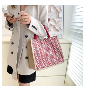 Fashionable large striped tote bag shown with model for size reference in a minimalist setting