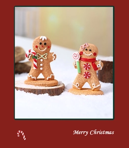 Detailed view of gingerbread man and girl figurines with candy canes and snow base