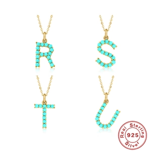 Detail of 925 sterling silver R S T U letter pendants with turquoise pavé setting