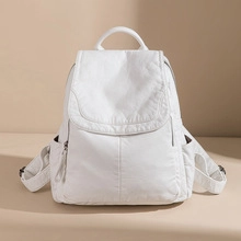 Close-up of white minimalist flap backpack with drawstring and side pocket detail