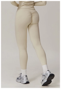 Detail view of high waist yoga pants with scrunch butt design in cream beige fabric