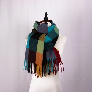 Macro detail of multi-colored plaid scarf featuring soft cashmere texture and long tassels
