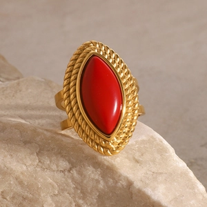 Detail of 18k gold vintage ring featuring marquise red stone on natural stone