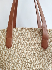 Two-tone woven paper rope tote bag with brown leather handles for beach or commute