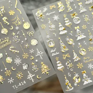 Close-up of 3D embossed Christmas nail stickers with gold reindeer and white snowflakes