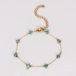 Detailed shot of handmade turquoise stones on a gold chain with lobster clasp