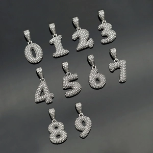 Flat lay of silver hip hop 0-9 bubble number pendants with micro paved iced out diamonds
