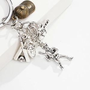 Macro view of vintage bronze baseball cap and silver sports charms on metal keychain