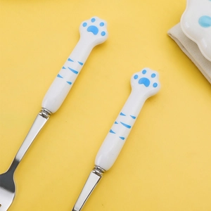 304 stainless steel cutlery set with blue cat paw ceramic handles on yellow background