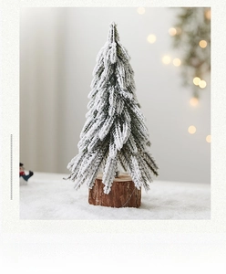 Close-up of a mini snowy Christmas tree with artificial snow and natural wood base