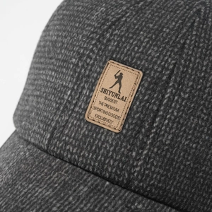 Macro detail of winter baseball cap texture with brown leather logo patch on front