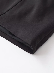 Détail macro de la texture du tissu noir tissé et des coutures fines d'un combishort