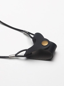 Close-up of heart-shaped black leather glasses strap with a golden metal button snap