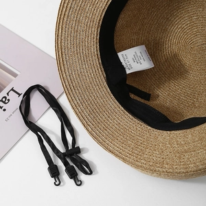 Detail of straw hat interior showing 57.5cm size label and adjustable windproof strap