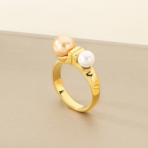 Detail of gold geometric ring featuring polished champagne and white pearls on band