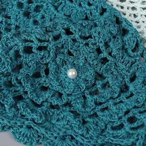 Béret au crochet vert foncé avec motif floral ajouré et détail de perle blanche