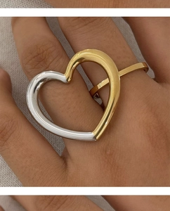 Close-up of oversized hollow heart-shaped ring in gold and silver two-tone finish