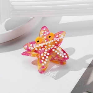 Starfish hair claw clip with colorful tie-dye patterns and dots on a white surface