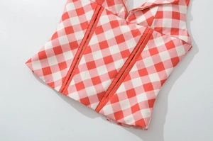 Detailed view of red and white checkered halter top with structured boning and V-neckline