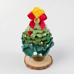 Detail of hand-knitted crochet Christmas tree with pearl beads and wooden base