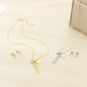 Detailed view of gold and silver MAMA jewelry sets with heart charms and crystal studs