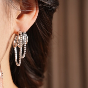 Vue détaillée de boucles d'oreilles multicouches argentées avec glands en zircone