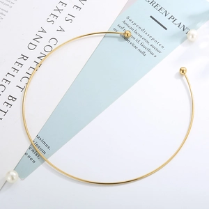 Detail view of a gold minimalist open collar necklace with pearl and small metal bead