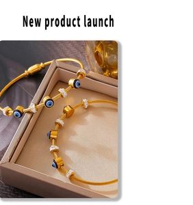 Dettaglio di braccialetti dorati Evil Eye con pavé di diamanti su portagioie