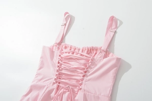 Detail of a pink dress showing the adjustable metal buckles and back lace-up closure