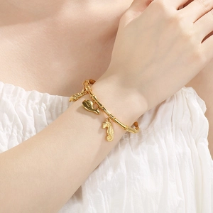 18K gold plated ocean charm bracelet featuring seahorse and whale pendants on wrist