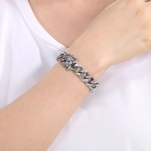 Macro shot of a silver 13mm cuban link bracelet with dragon clasp on a model's wrist