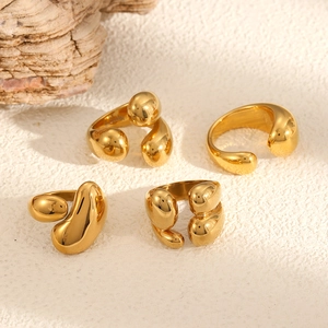 Abstract geometric 18K gold-plated stainless steel teardrop rings on stone texture