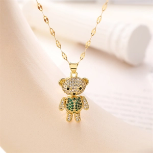 Macro shot of gold teddy bear pendant featuring sparkling green and clear cubic zirconia