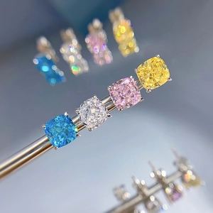 Detailed macro view of four cushion-cut colored gems in blue, white, pink and yellow
