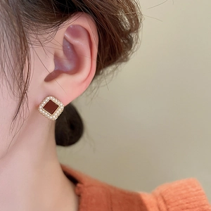 Détail de boucle d'oreille vintage carrée avec pierre rouge et perles sur l'oreille