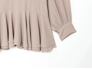 Detalle de vestido rosa palo con dobladillo de volantes y puños con botones elegantes