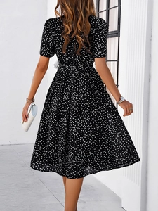 Vue de dos d'une robe mi-longue à pois noirs et blancs avec manches courtes et ceinture