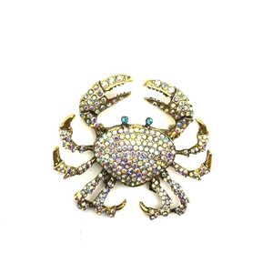 Vintage style crab brooch with colorful rhinestones on a polished golden metal base