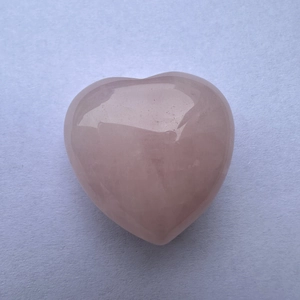 Macro shot of 3cm heart-shaped pink rose quartz stone with natural crystal textures