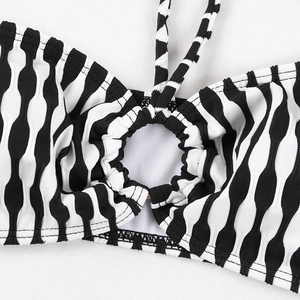 Détail d'un haut de bikini rayé noir et blanc avec anneau central et tissu texturé