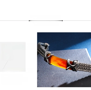 Detailed macro view of 316L stainless steel braided chain bracelet with orange inlay