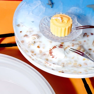 Detailopname van een geurkaars in de vorm van een maancake in een glazen schaal