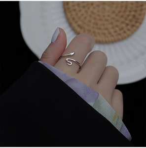 Nahaufnahme eines minimalistischen silbernen Schlangenrings getragen am Finger im modernen Stil