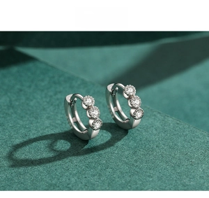 Macro detail of S925 sterling silver hoop earrings with three round-cut sparkling zircons