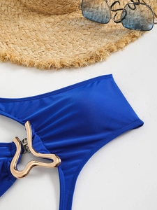 Detail of blue swimsuit with luxury gold metallic buckle and sunhat for summer beach vacation