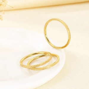 Detailansicht minimalistischer goldener mattierter Edelstahlringe auf weißem Teller